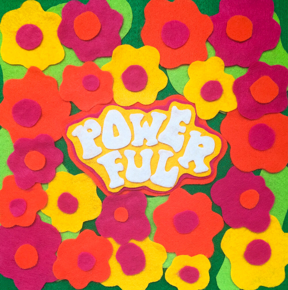 A felt collage illustration depicting a collection of colourful flowers on a green background, with the word “Powerful” in white text.