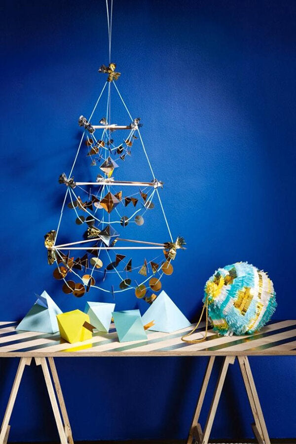 A collection of blue, yellow, white and metallic holiday-themed props are styled in a glamorous setting with confetti accents. 