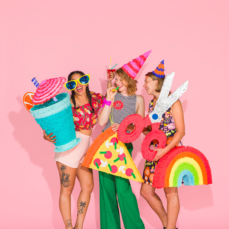 Spread from Kitiya Palaskas' Pinata Party book featuring a group of colourfully dressed women with pinatas